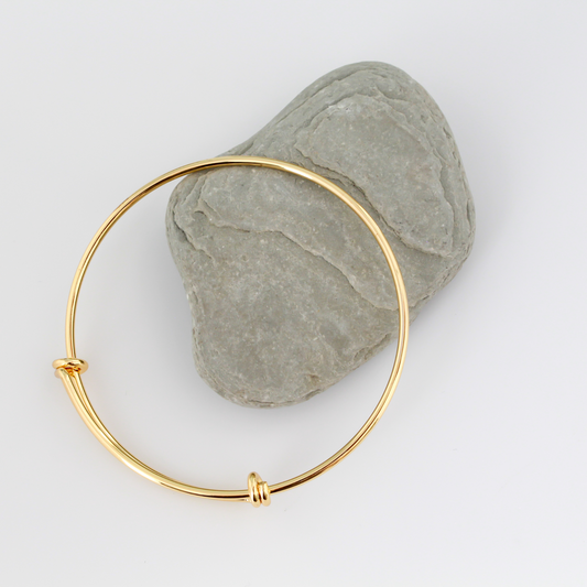 Adjustable bangle bracelet that you can wear as is or add charms to. Copper base with 18k gold plating.