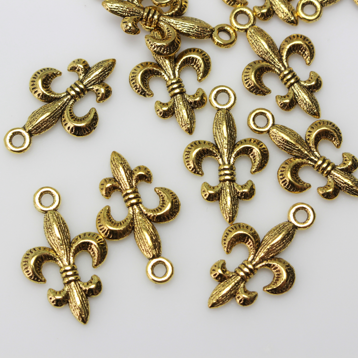 Antiqued gold tone fleur de lis charm, 24mm long