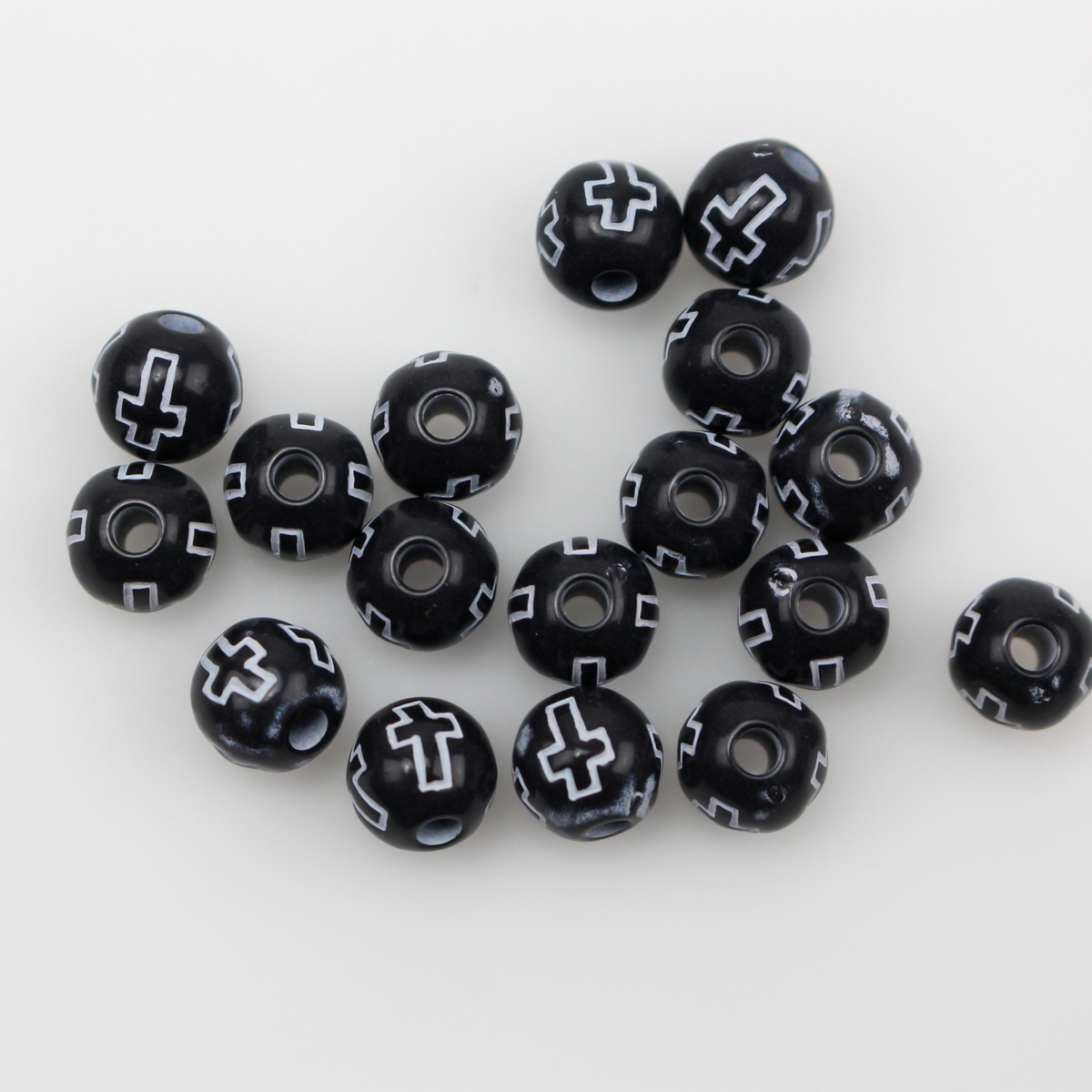 Black acrylic beads with a white etched cross design. The beads are 8mm round with a 2mm hole size.