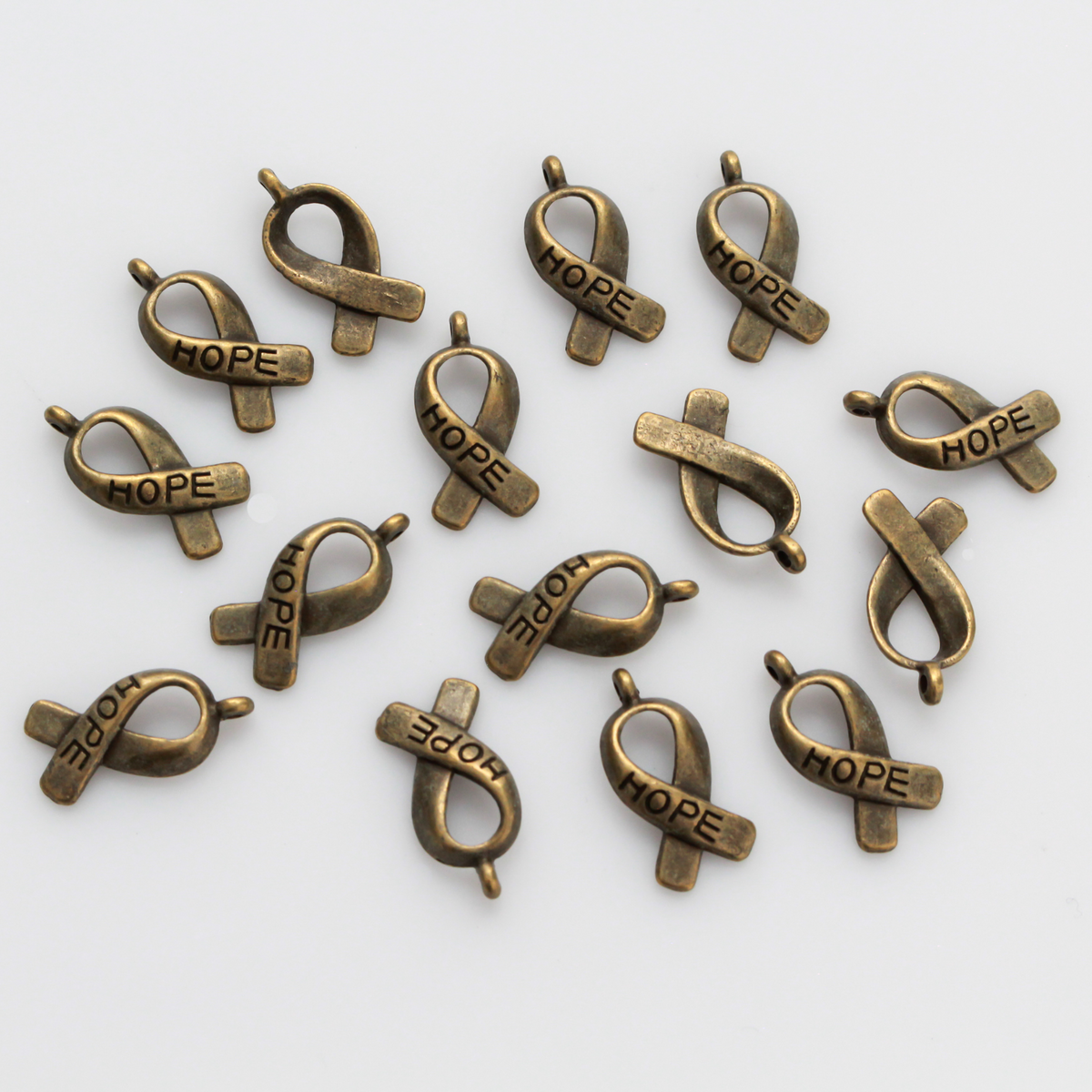 Bronze awareness ribbon charms with the word "HOPE" engraved on the ribbon, 18mm long