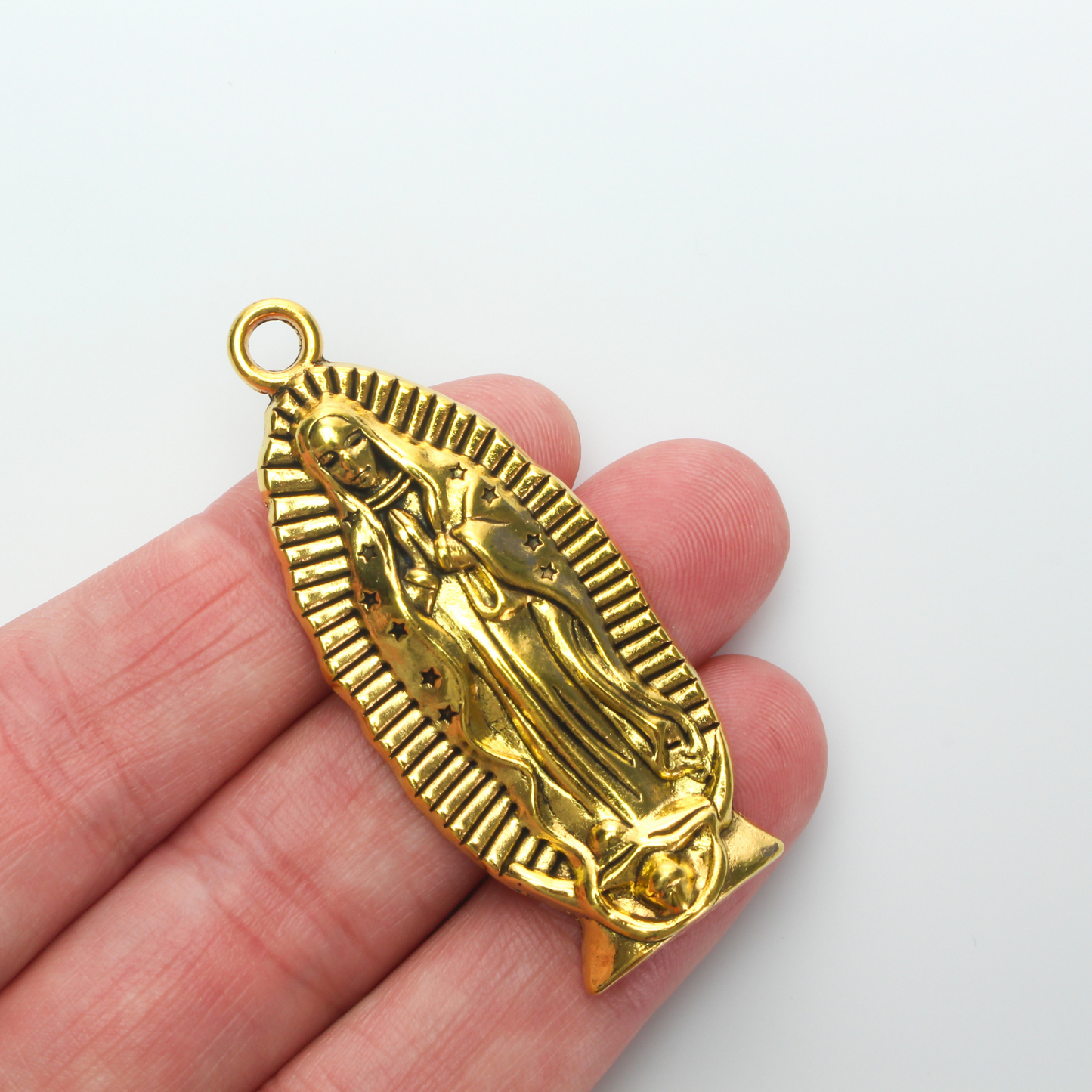 A beautifully detailed pendant of Our Lady of Guadalupe. This large charm is two inches long with a flat, plain back