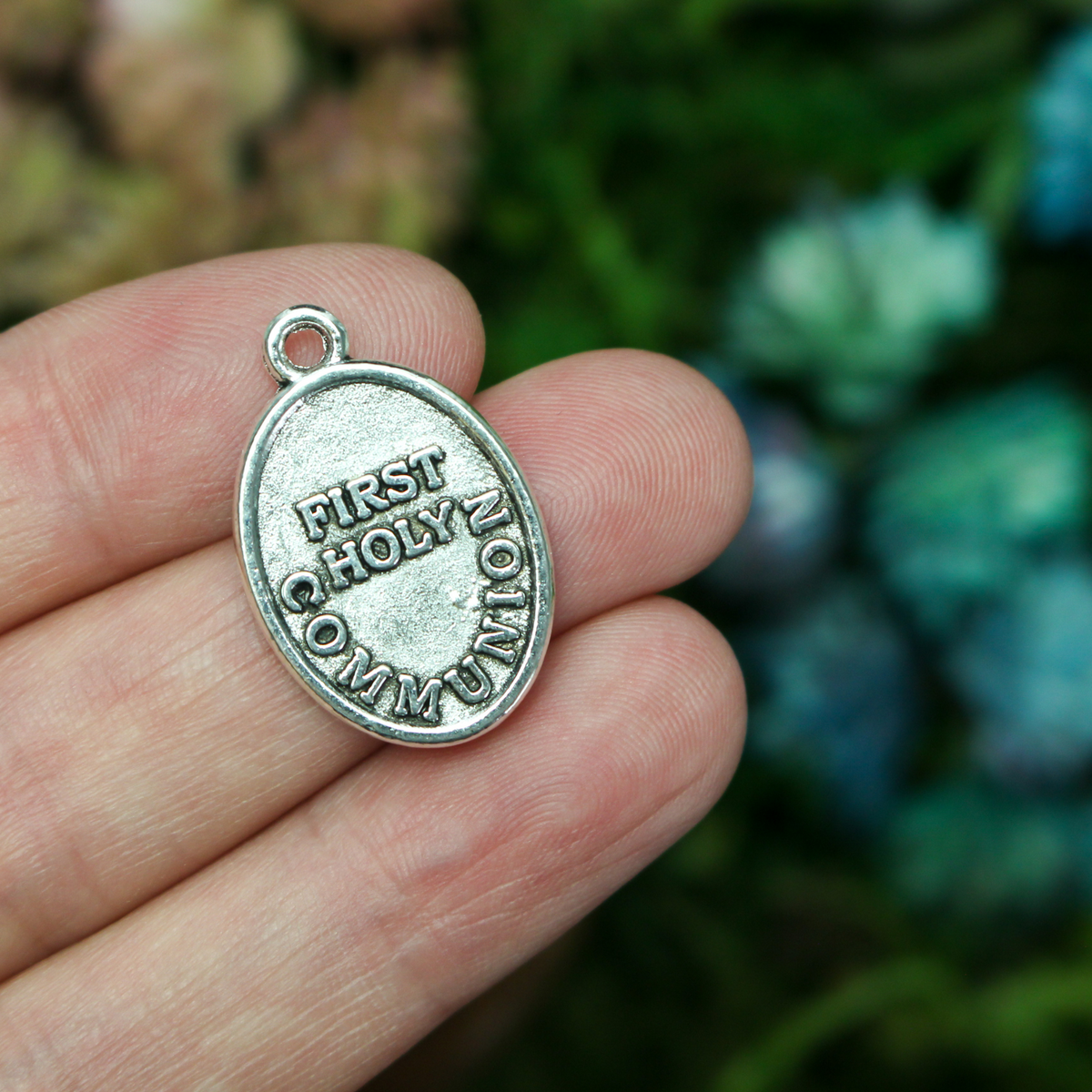 Holy Eucharist medal with "First Holy Communion" on the back