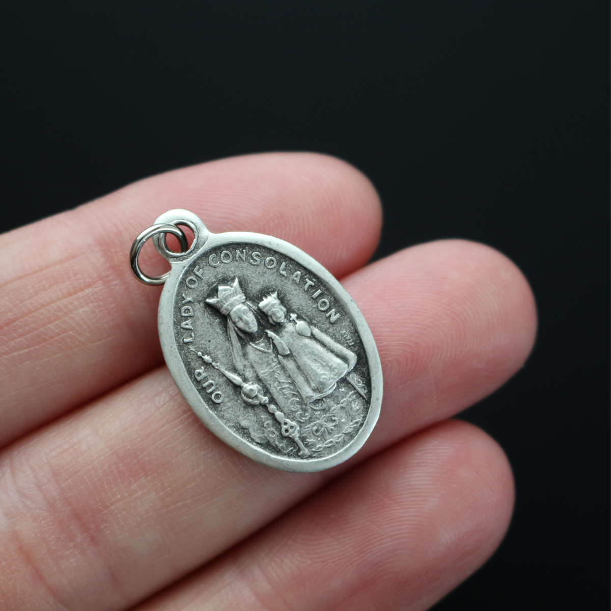 Our Lady of Consolation medal that depicts Our Lady on the front and the Shrine of Our Lady of Consolation in Carey, Ohio on the backside