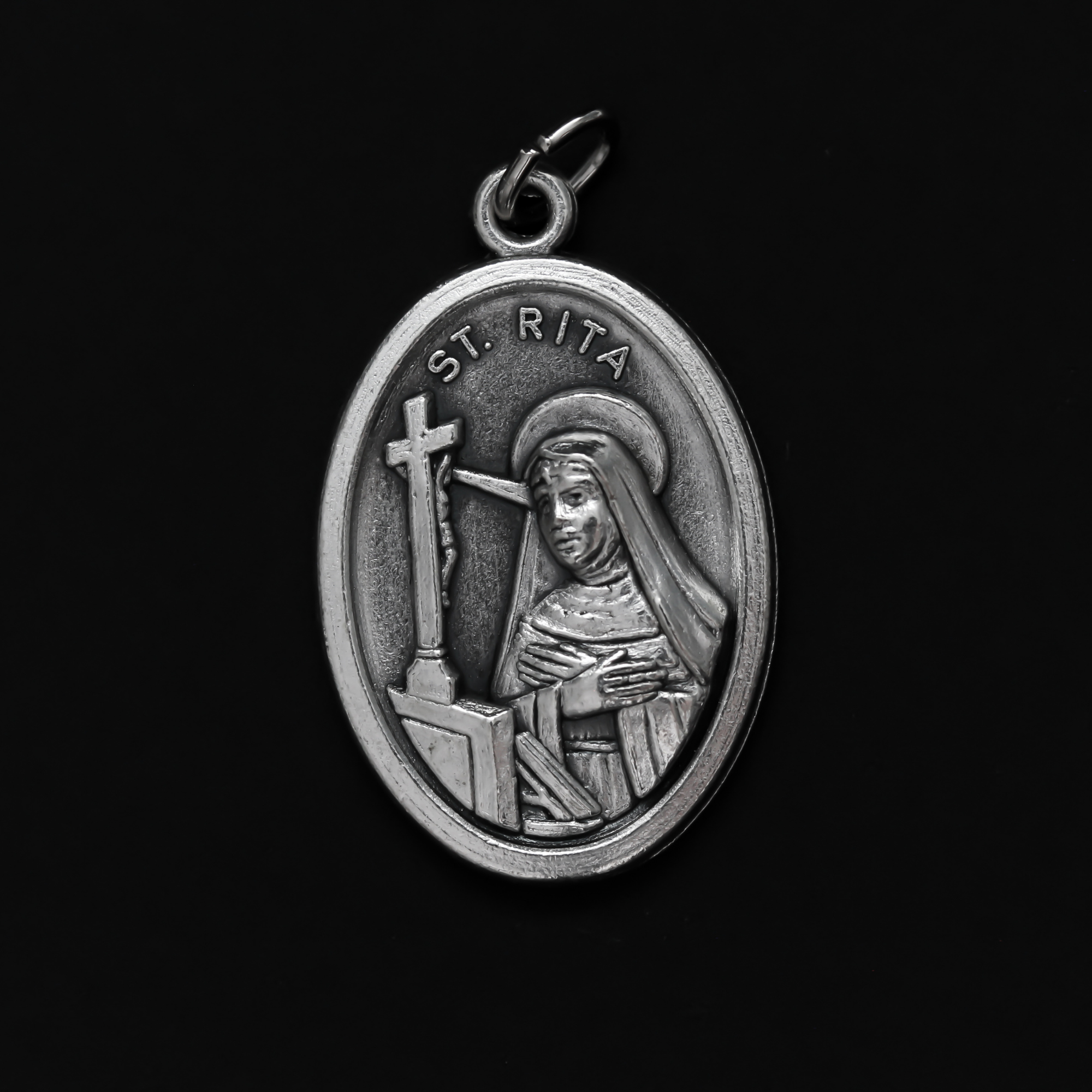 Saint Rita medal that depicts the saint on the front and "Pray For Us" on the back