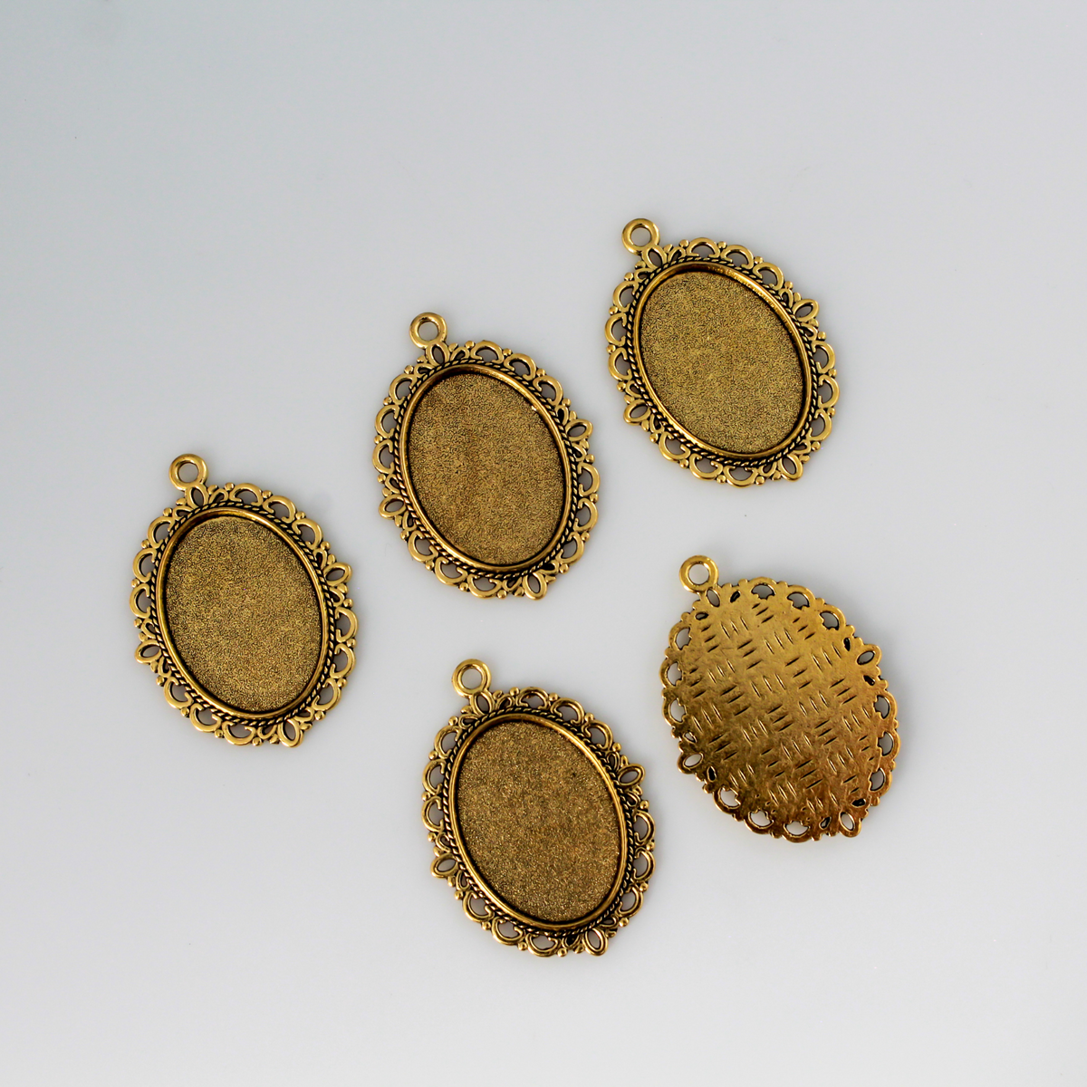oval pendant cabochon setting in an antiqued gold color. This is an ornate edge bezel cup with a 25mm x 18mm tray.