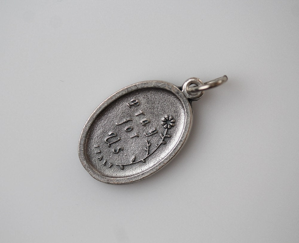 die cast silver medal inscribed with pray for us