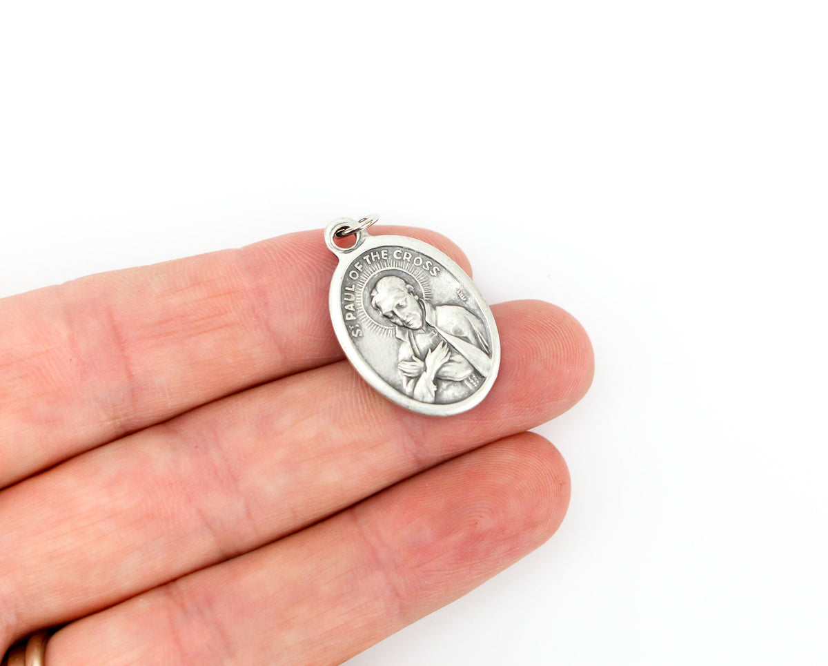 womans hand holding catholic patron saint paul medal
