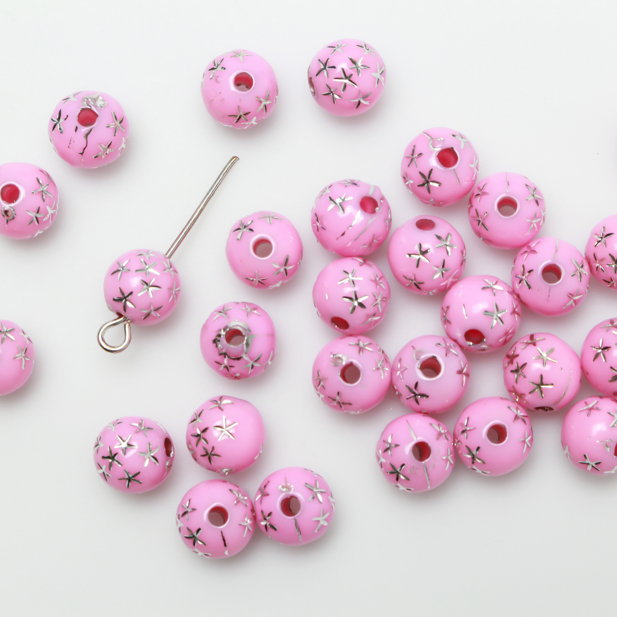 8mm Round pink opaque beads that have a silver star design etched into them.