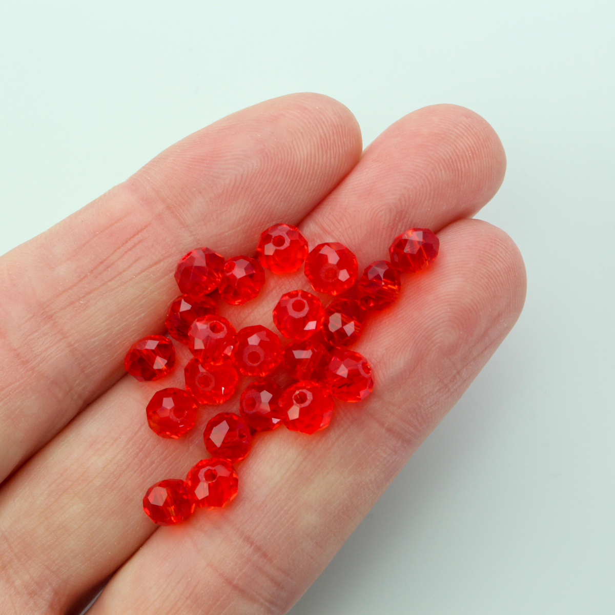Asian cut crystal glass beads. 6mm x 4mm faceted red transparent. Sold in packages of 60 beads