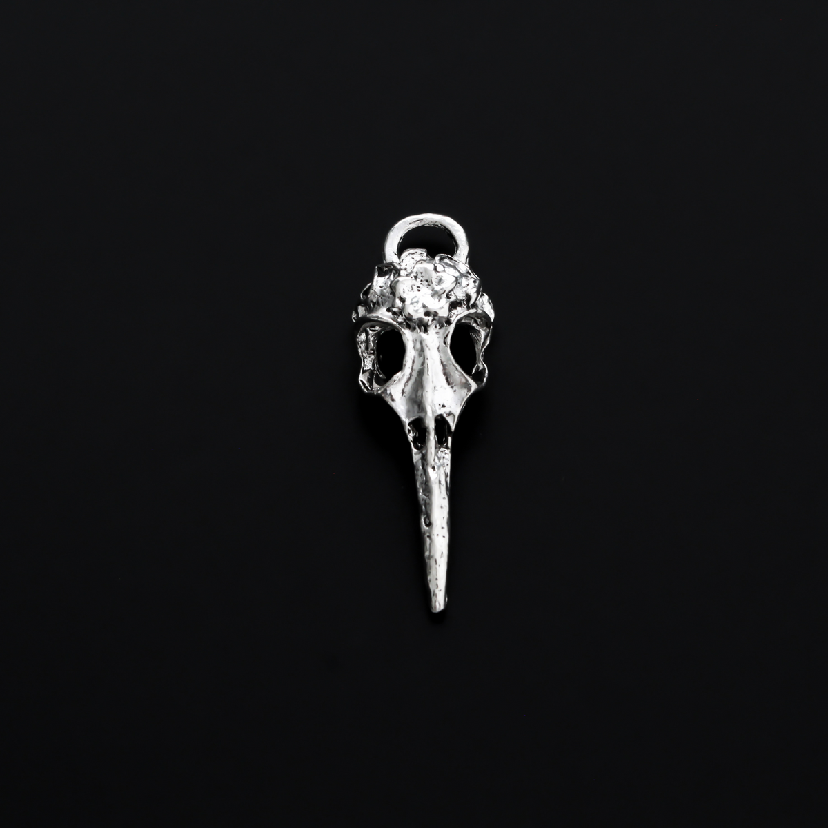 Antiqued silver tone raven skull charms that have a flower design on the top