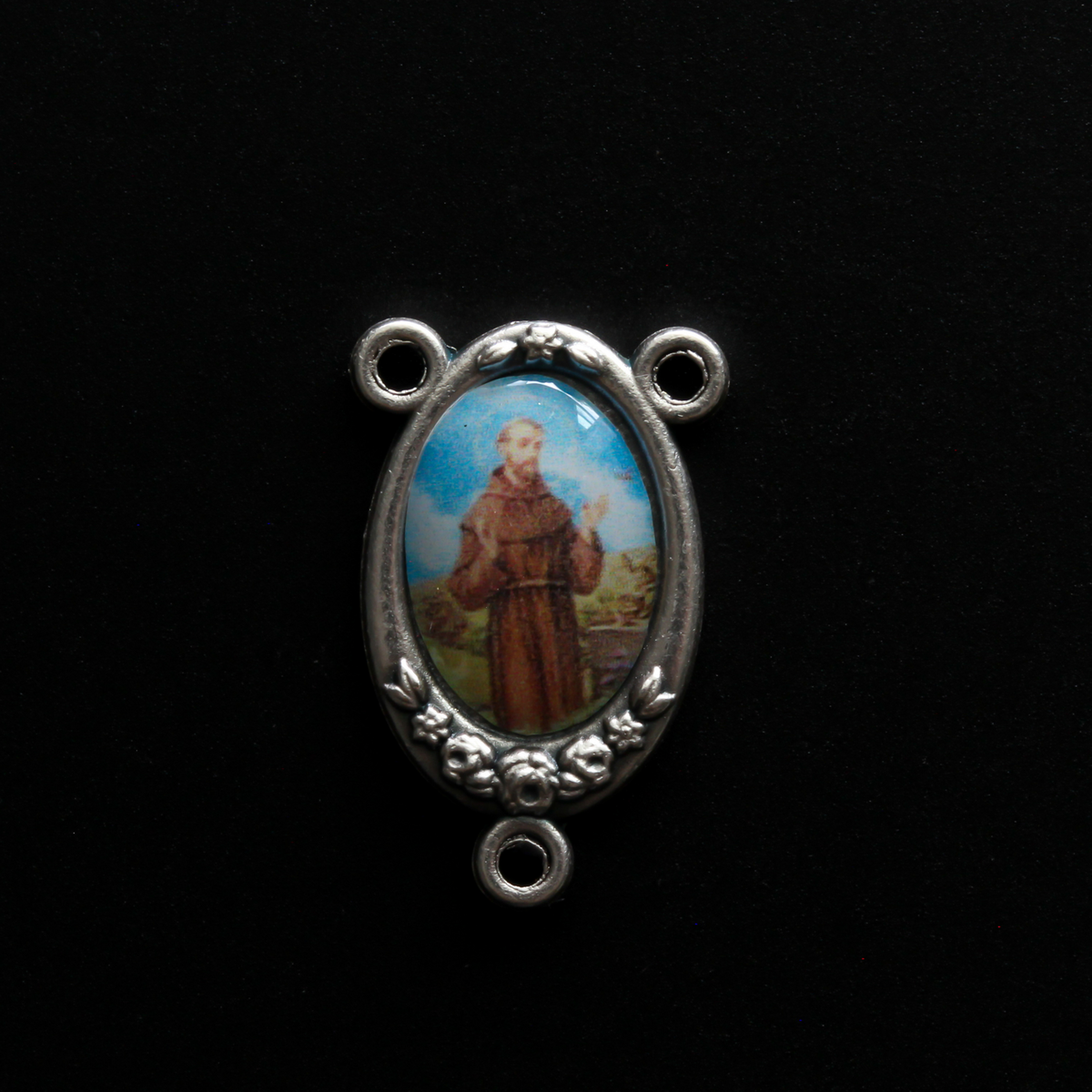 rosary center that has a full-color image of Saint Francis of Assisi inlaid in a silver oxidized center with flower details on the edge