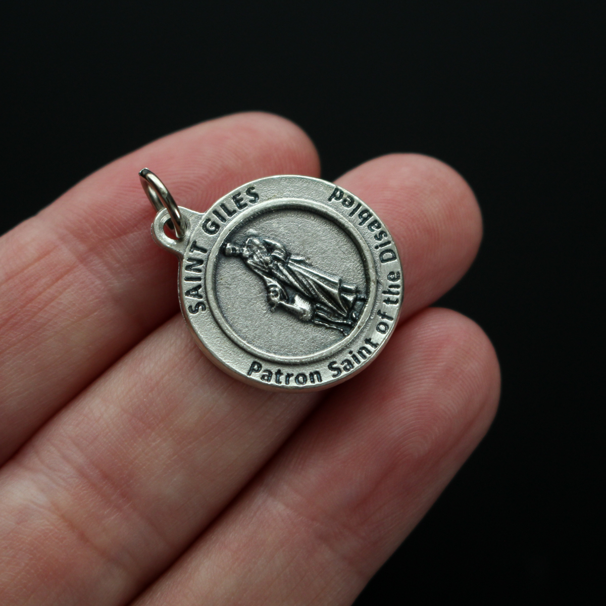 Saint Giles 3/4" round medal. The front depicts the saint and the reverse is marked "Patron Saint of the Disabled".
