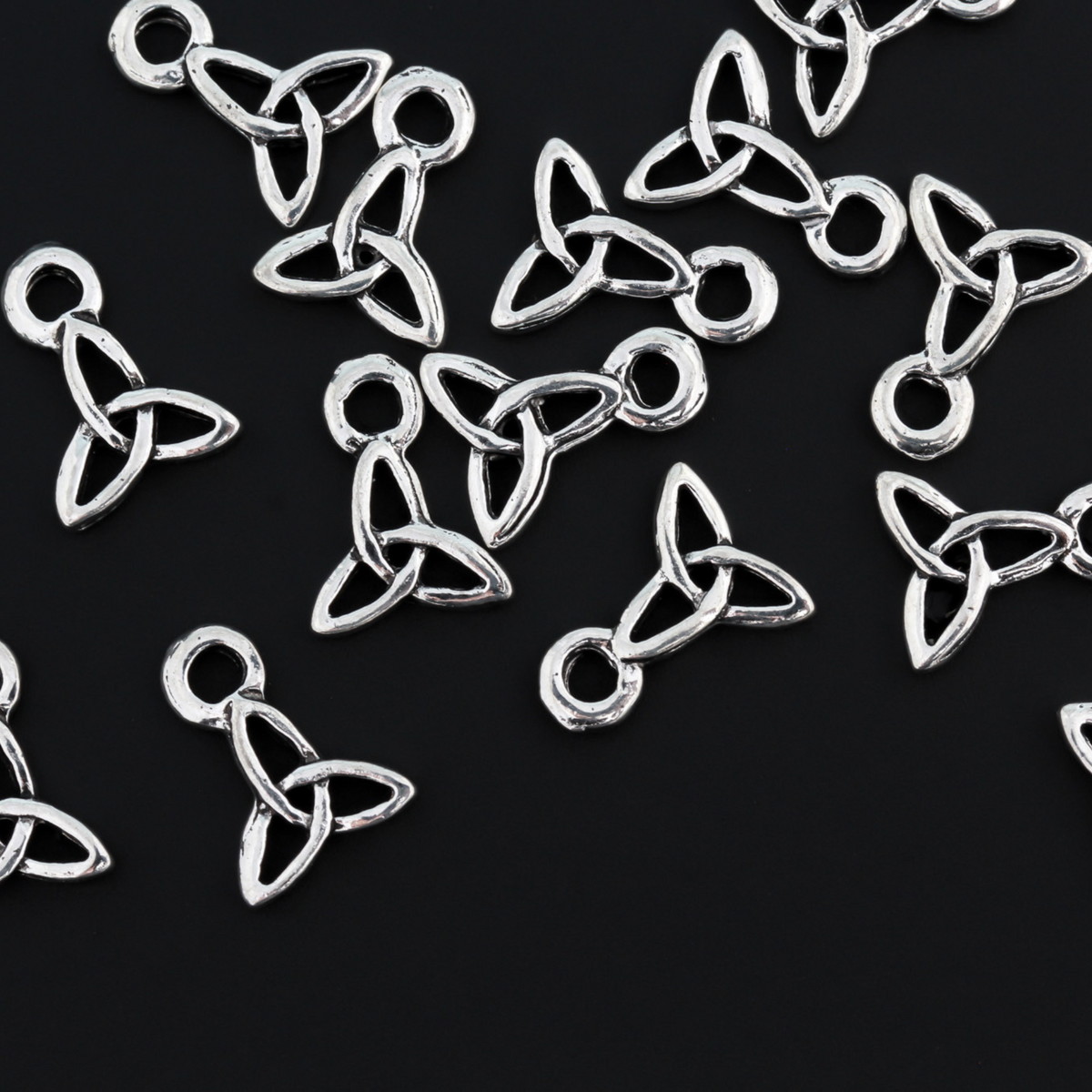 Celtic trinity knot charms that are an antiqued silver tone color. The trinity knot is a symbol of the the holy trinity