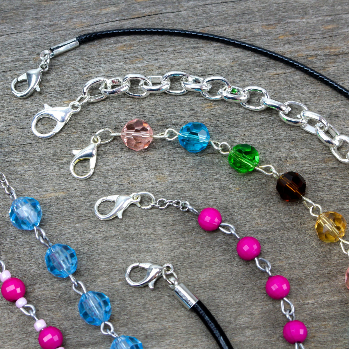 variety of bracelets and charms displayed on driftwood