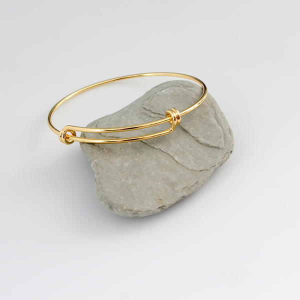 Adjustable bangle bracelet that you can wear as is or add charms to. Copper base with 18k gold plating.