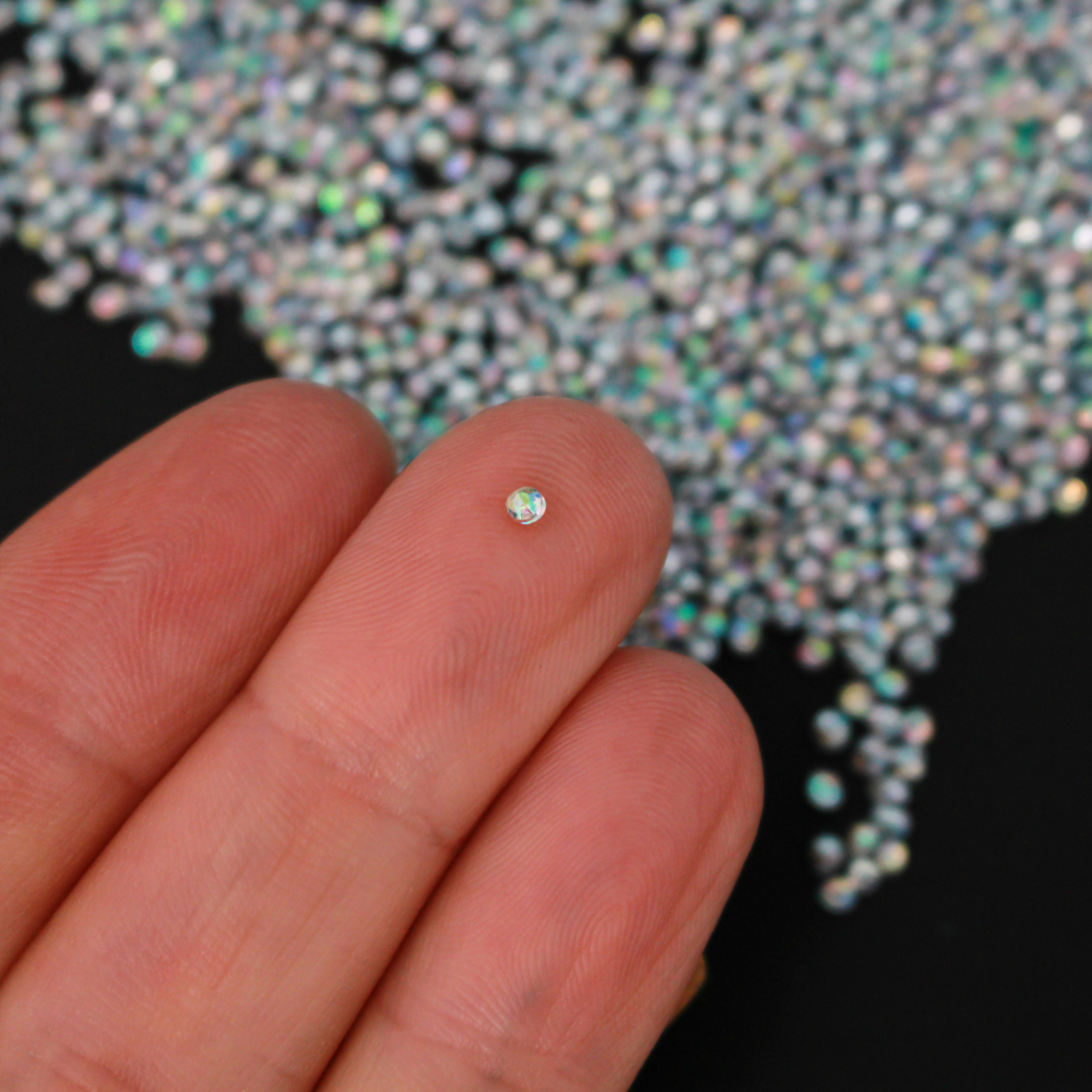 Tiny acrylic (imitation) rhinestones that are an AB crystal color with a pointed back and faceted front