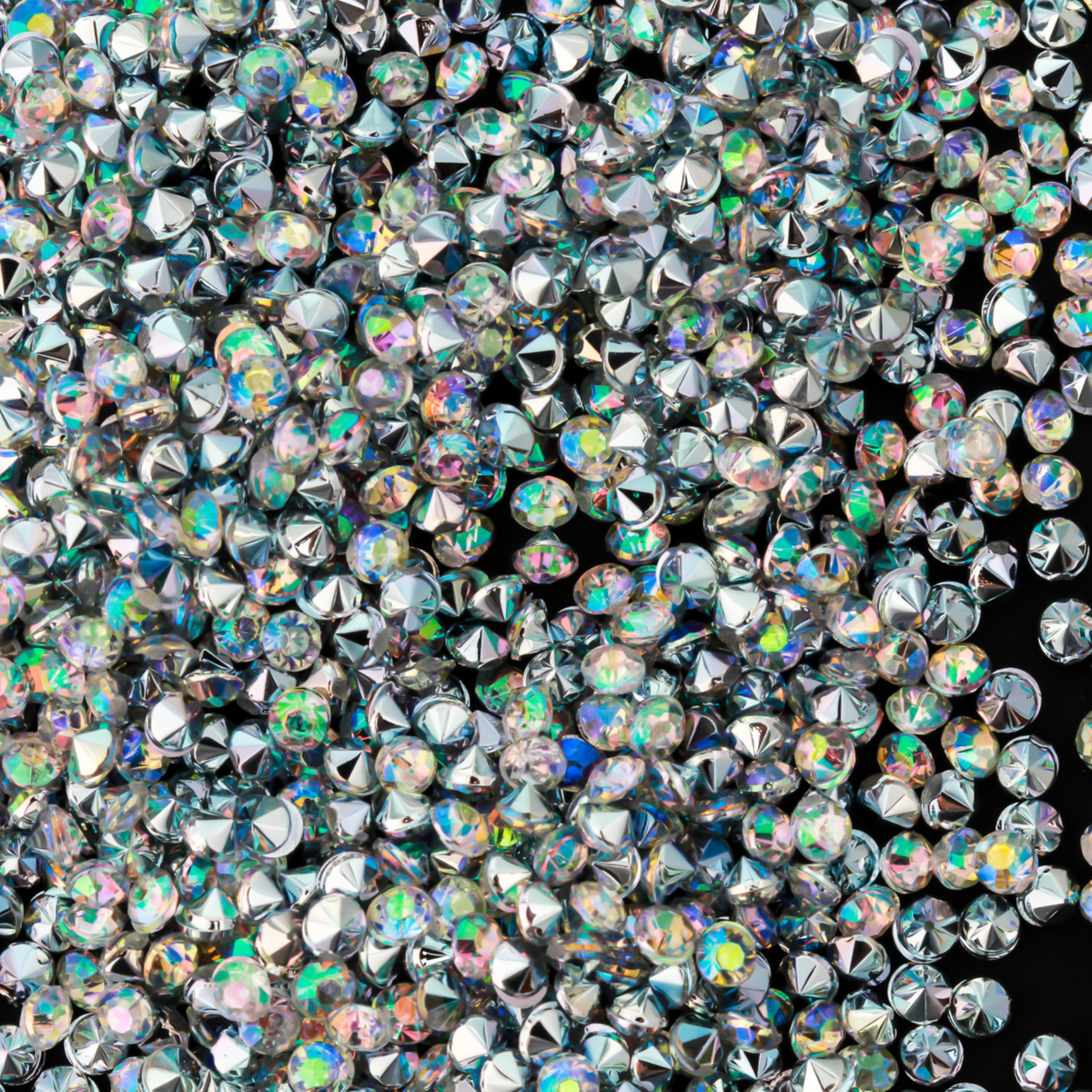 Tiny acrylic (imitation) rhinestones that are an AB crystal color with a pointed back and faceted front