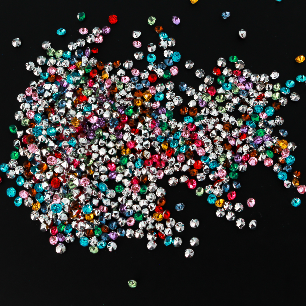 Tiny acrylic (imitation) rhinestones that are a random mix of colors with a pointed back and faceted front