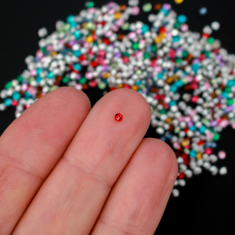 Tiny acrylic (imitation) rhinestones that are a random mix of colors with a pointed back and faceted front
