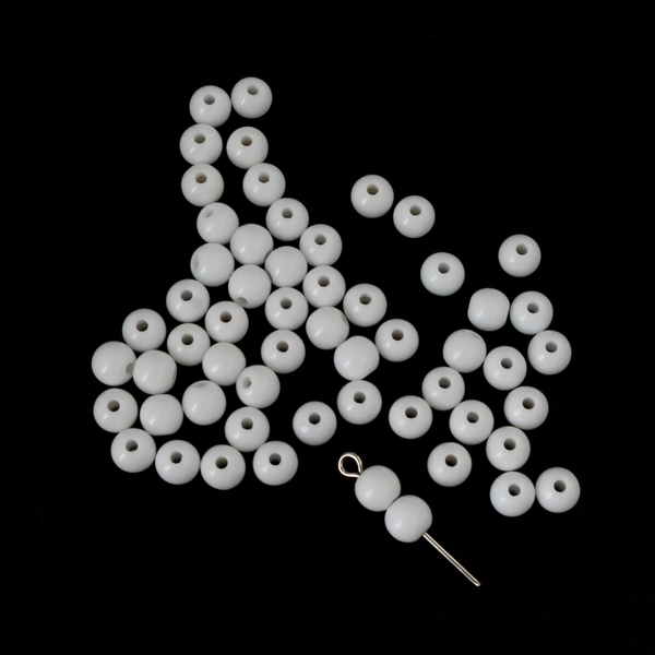 Round white opaque beads that are 6mm in diameter with a 1mm hole siz