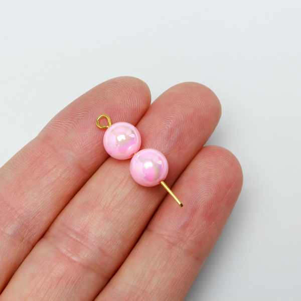 8mm round pink beads that are AB plated (Aurora Borealis) giving them a iridescent metallic look.