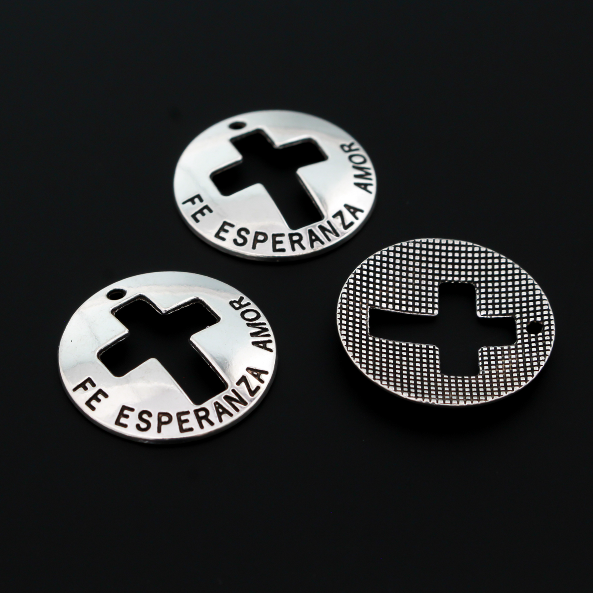 Fe, Esperanza, Amor - Spanish for Faith, Hope, Love. These charms are round with a slight curve and a cut out cross in the center