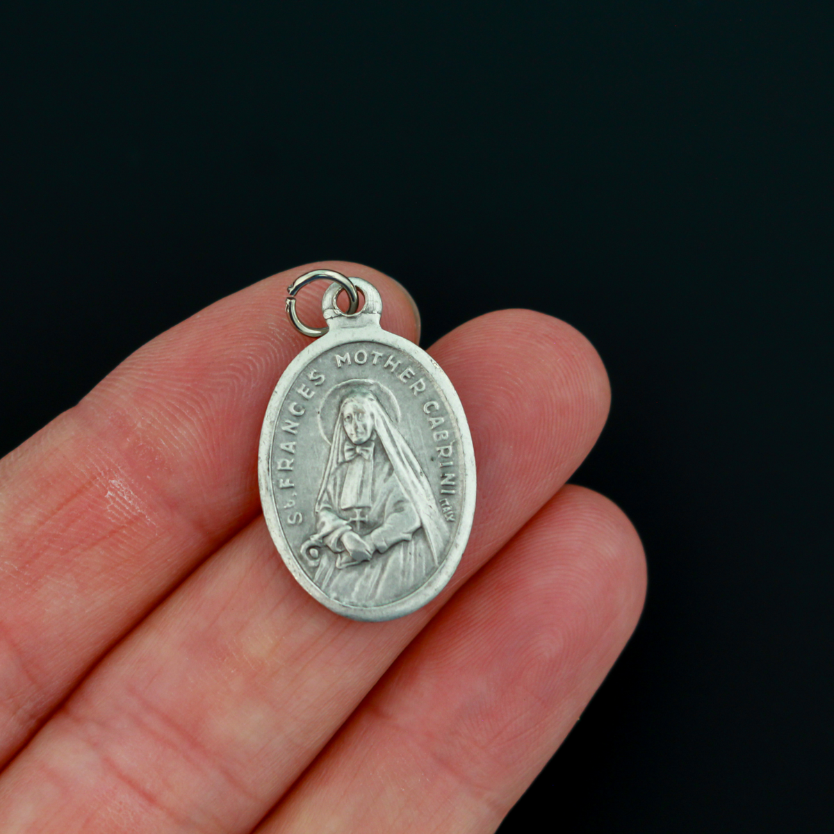 Saint Frances Mother Cabrini medal that depicts the saint on the front and "Pray For Us" on the back