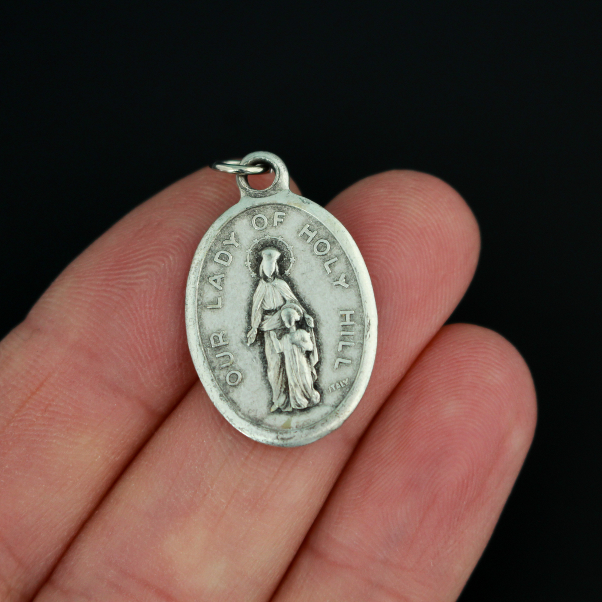 Our Lady of Holy Hill medal that depicts Mary on the front and the Holy Hill Basilica in Wisconsin on the back