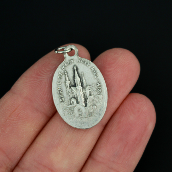 Our Lady of Holy Hill medal that depicts Mary on the front and the Holy Hill Basilica in Wisconsin on the back