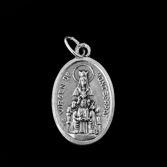 Our Lady of Montserrat medal that depicts Mary on the front and the Sacred Heart of Jesus on the back