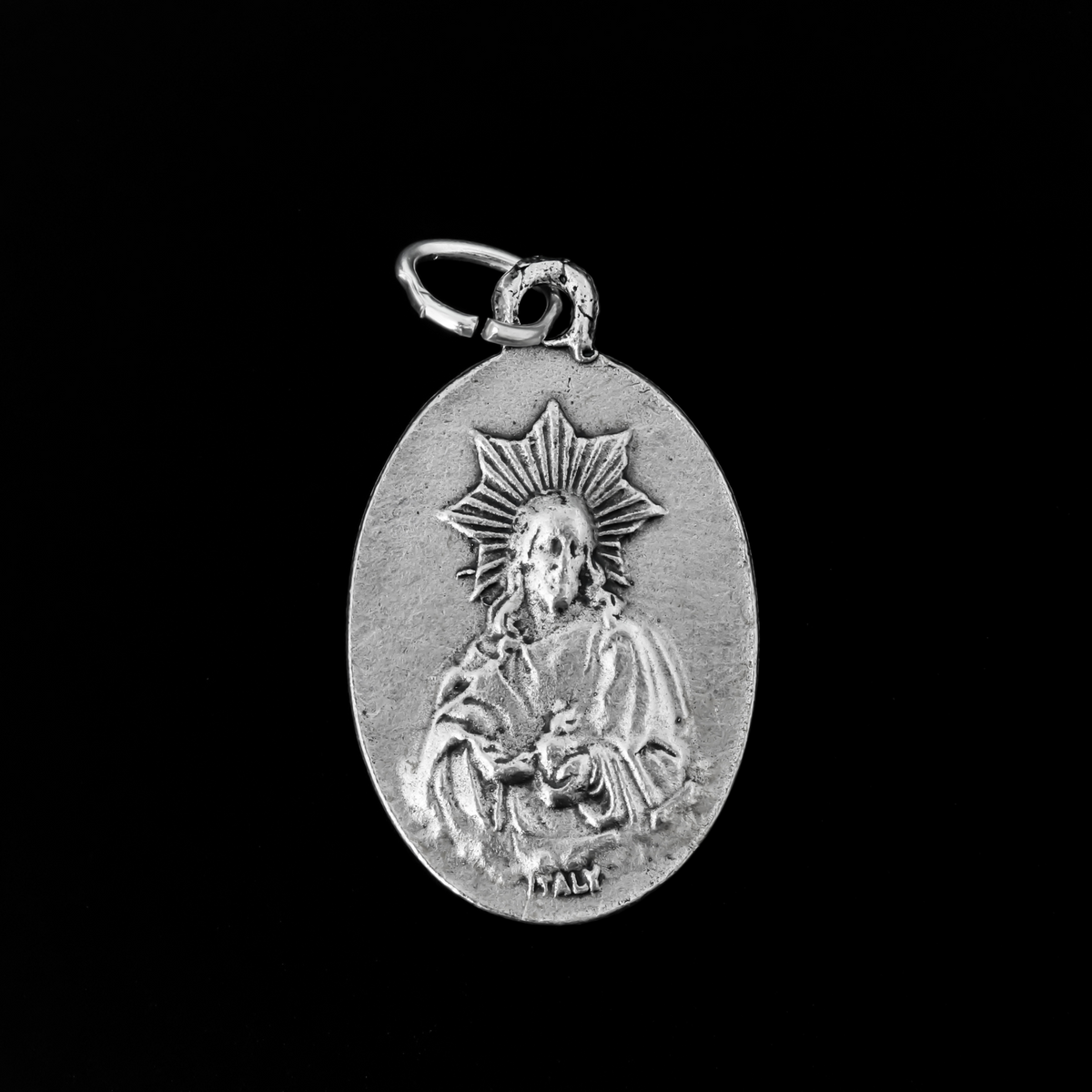 Our Lady of Montserrat medal that depicts Mary on the front and the Sacred Heart of Jesus on the back