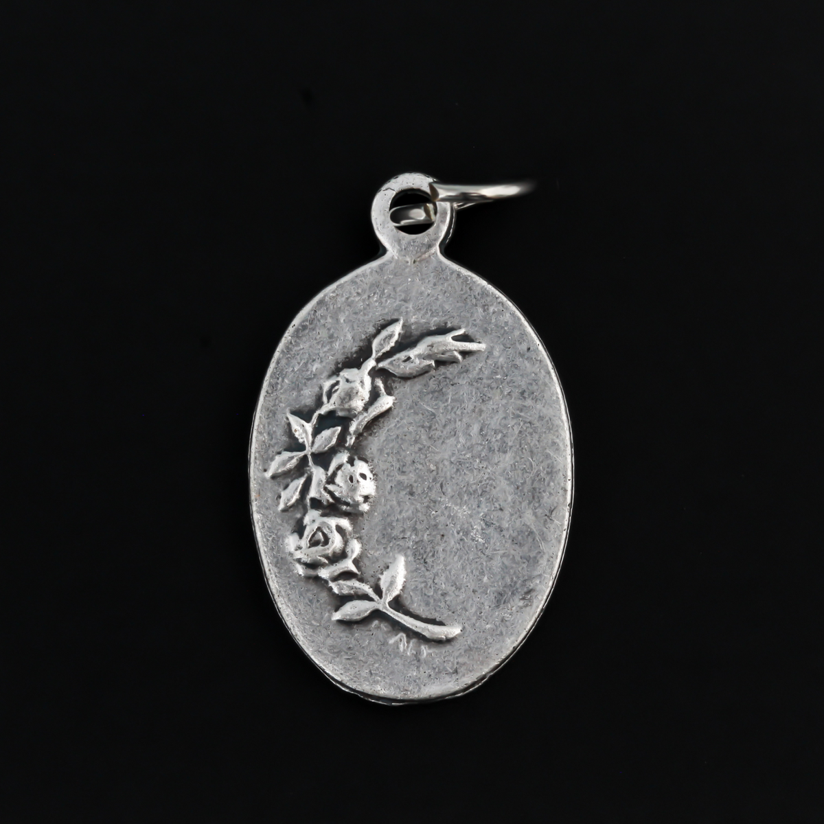 Our Lady of Regla Medal that depicts Mary on the front and flowers on the back