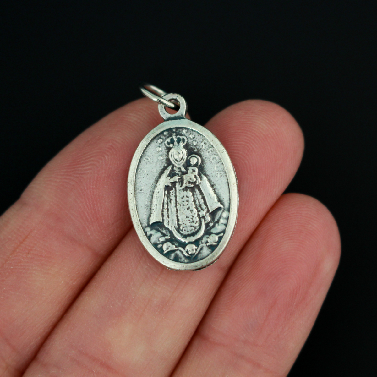 Our Lady of Regla Medal that depicts Mary on the front and flowers on the back