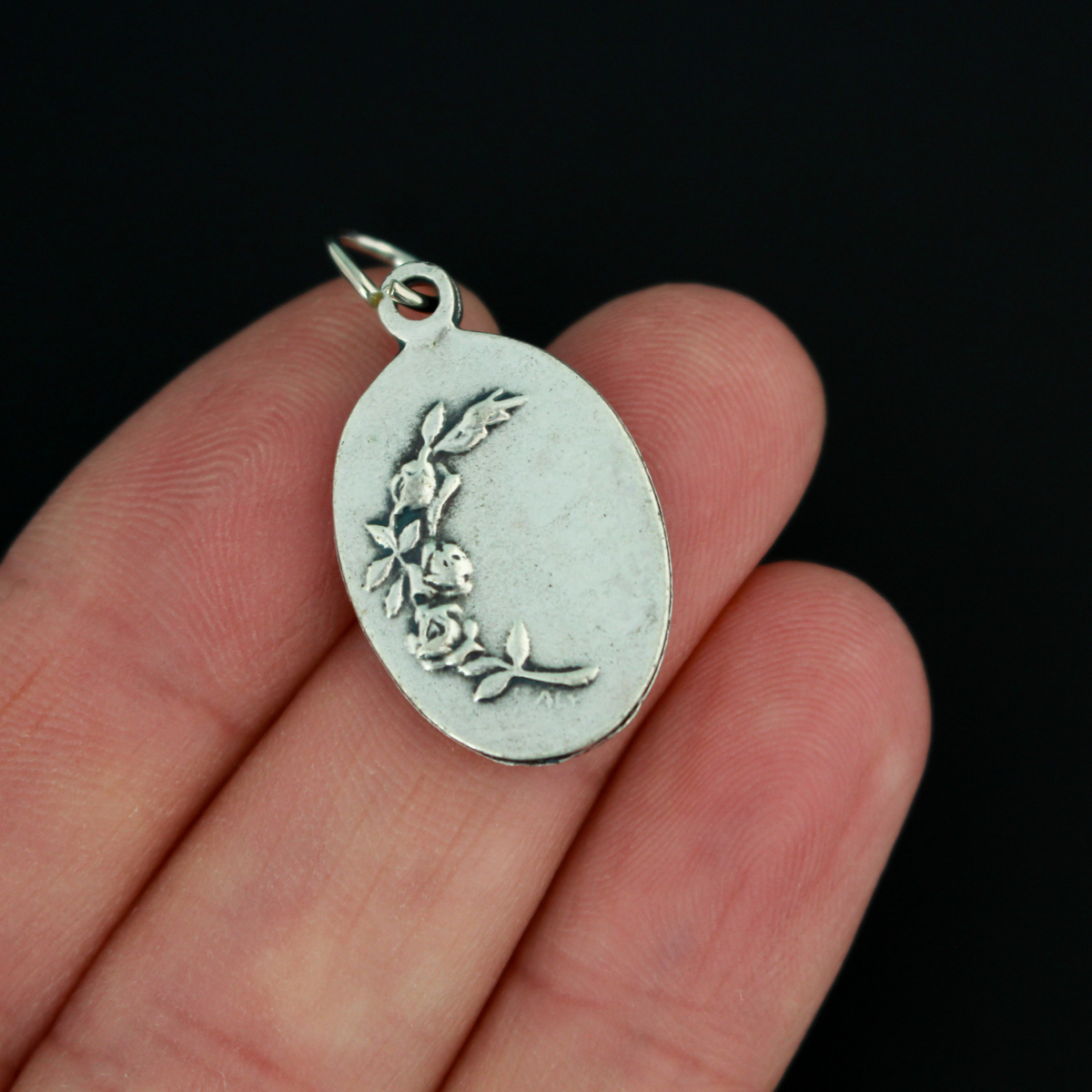 Our Lady of Regla Medal that depicts Mary on the front and flowers on the back