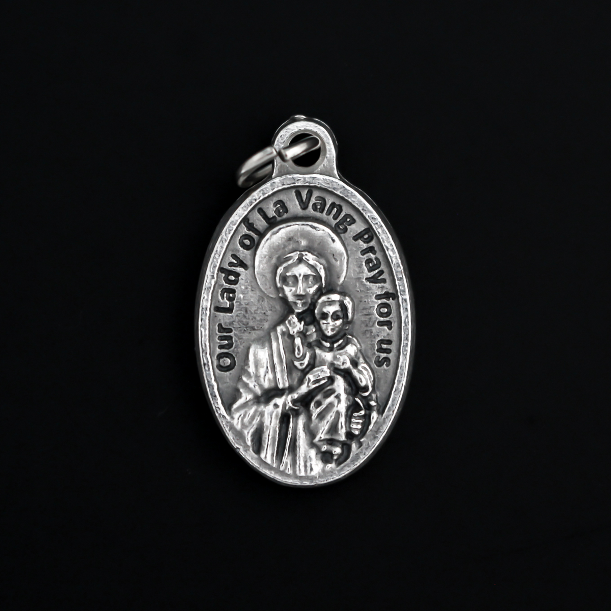 St. Andrew Dung Lac medal that depicts the saint on the front and Our Lady of La Vang on the backside