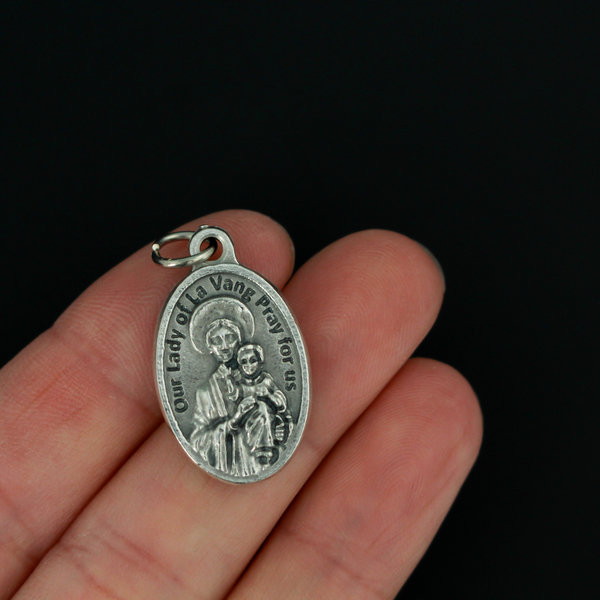 St. Andrew Dung Lac medal that depicts the saint on the front and Our Lady of La Vang on the backside