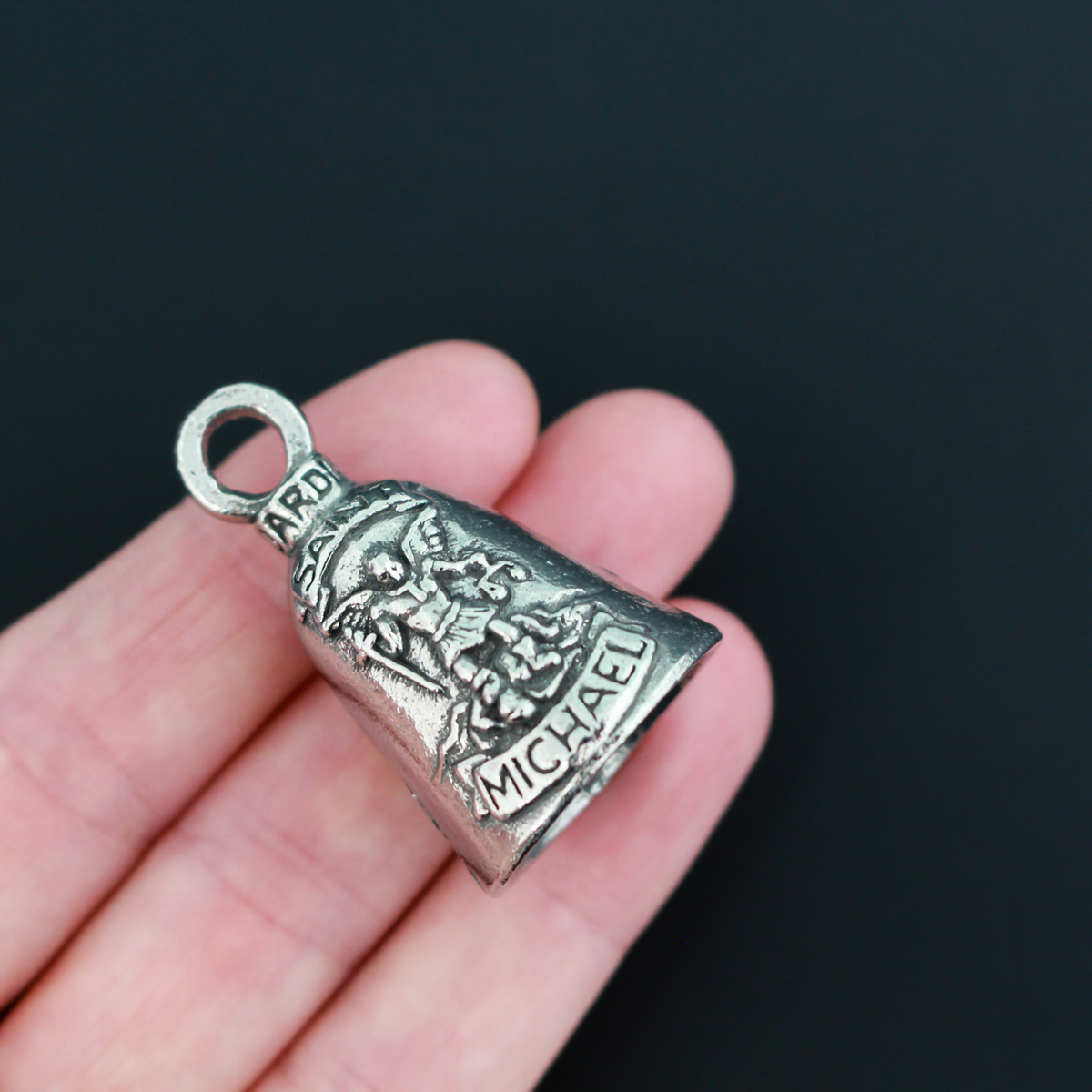 Saint Michael Guardian bell that depicts the saint on the front and is marked "Patron Saint of Law Enforcement" on the back