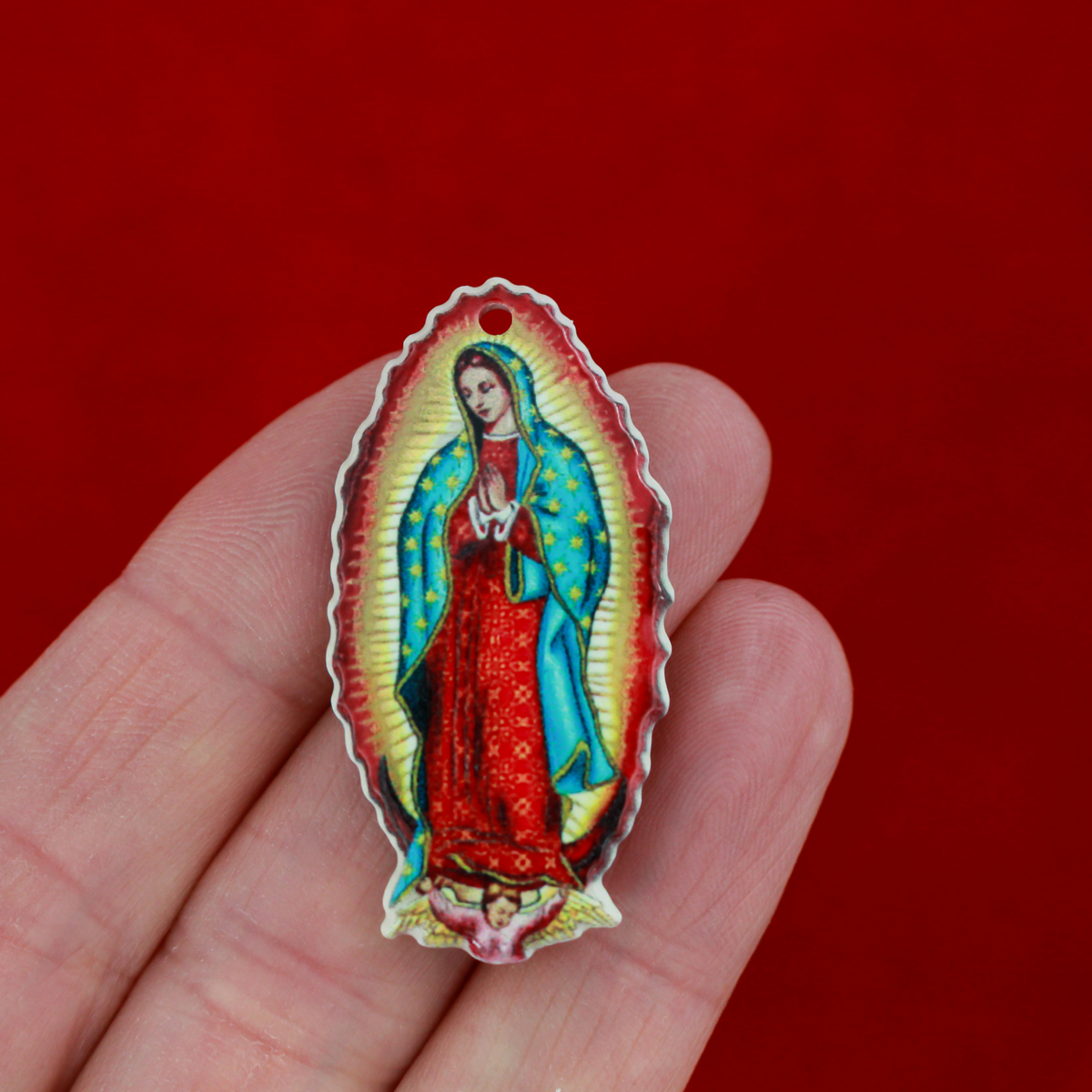 crylic pendants with a printed full color image of Our Lady of Guadalupe. The image is reversed on the backside