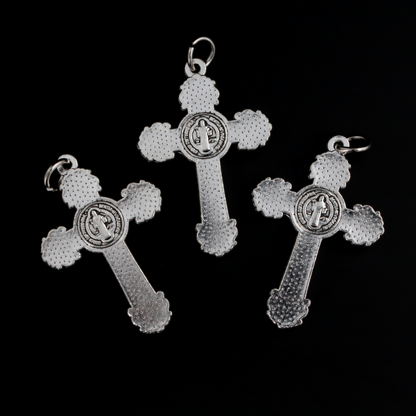 ornate crucifix crosses in an antiqued silver-tone color with the medal of Saint Benedict behind Jesus