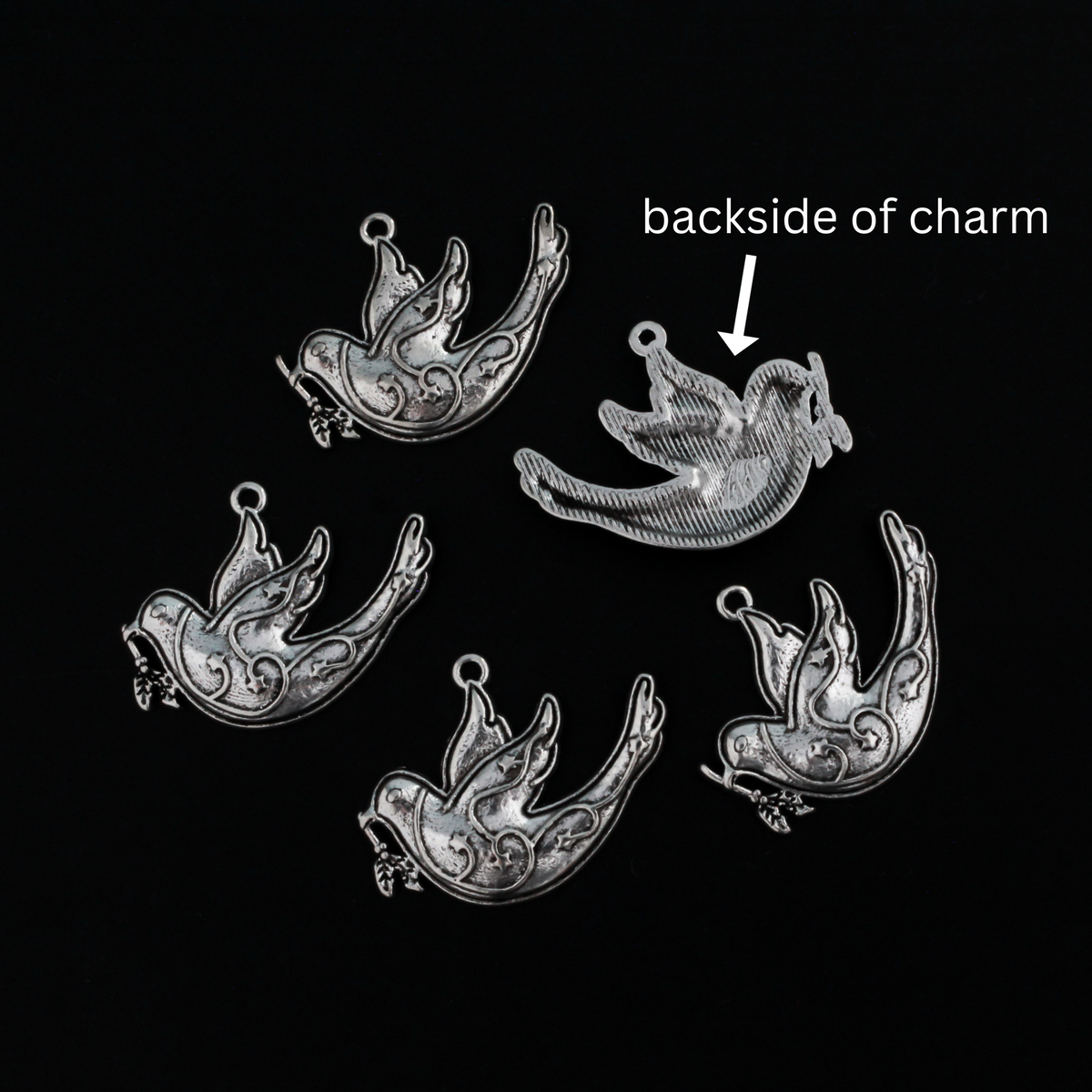 silver tone dove charm carrying an olive branch which is a symbol of peace, 28mm x 22mm
