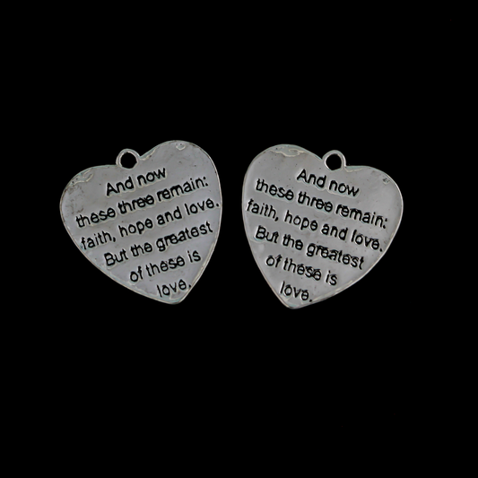 Shiny silver heart charms engraved with a bible passage from First Corinthians 13:13 “And now these three remain: faith, hope and love. But the greatest of these is love." The backside of the charm is blank with a pattern.