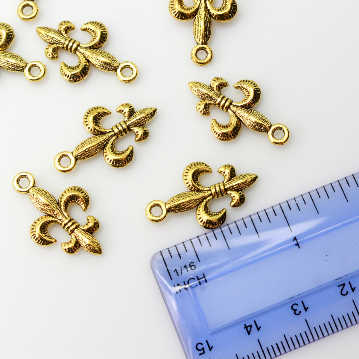 Antiqued gold tone fleur de lis charm, 24mm long