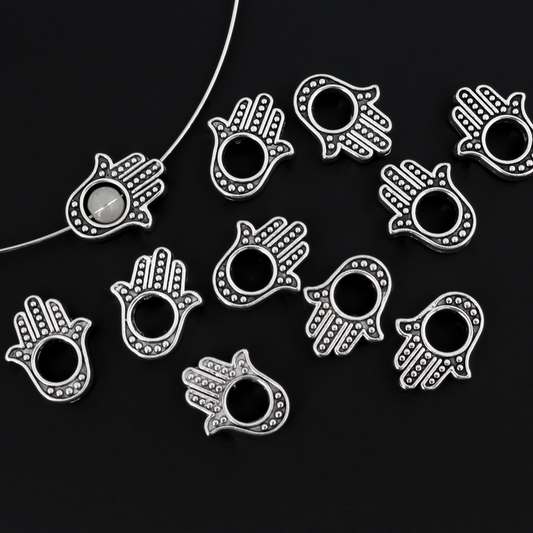 Hamsa hand bead frame crafted of zinc alloy and plated with an antiqued silver finish, it features a raised dot pattern on both sides and fits a 4mm round bead or smaller