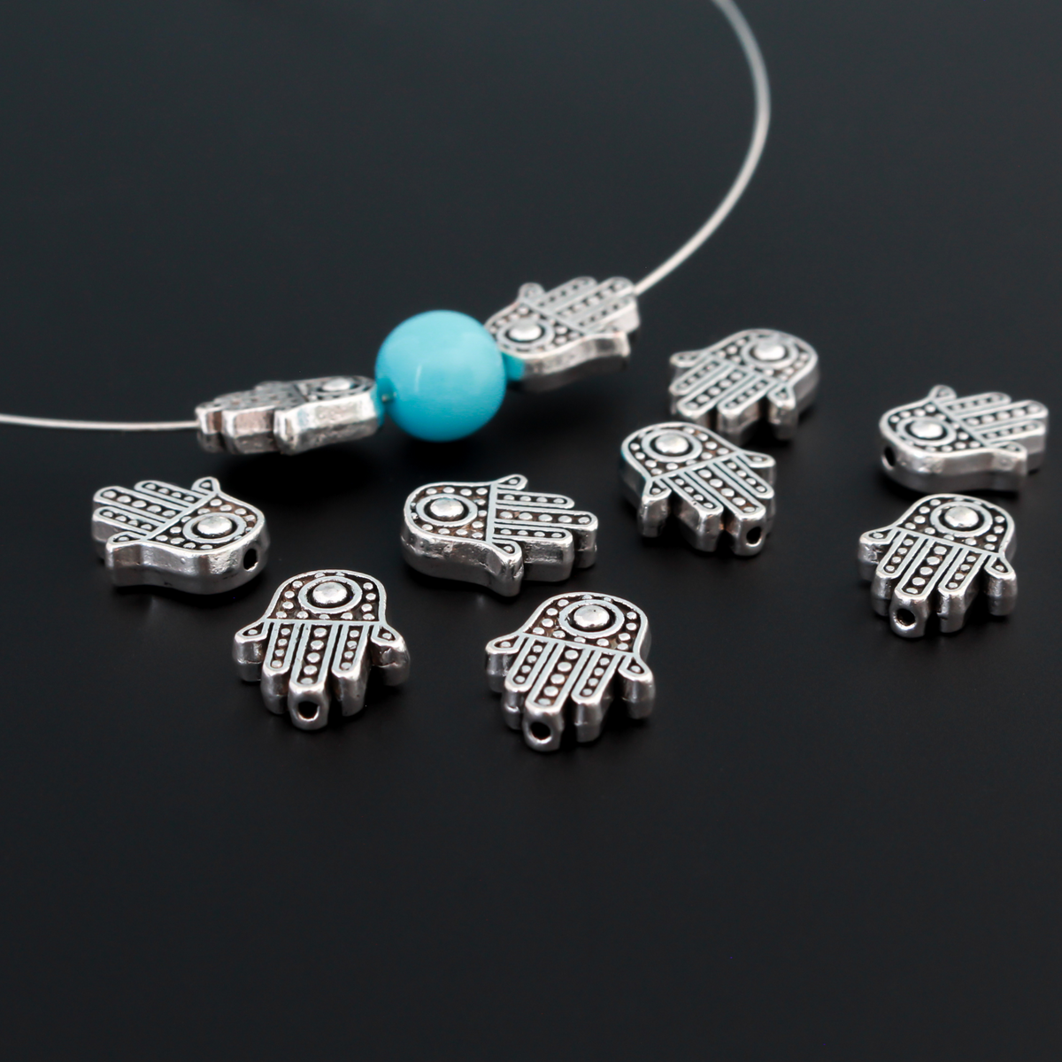 antiqued silver tone hamsa hand beads that are 12mm long by 10mm wide with 1.5mm hole