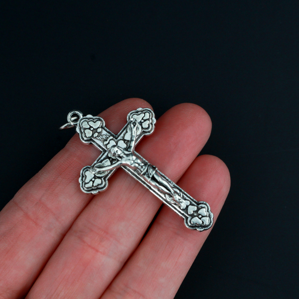 Detailed crucifix that is Byzantine in style with a heart design on the crossbeams behind the body of Jesus.