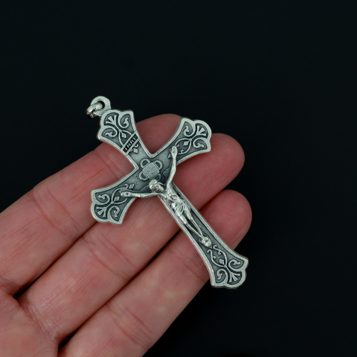 Large ornate crucifix with flared edges. Beautiful raised relief scroll work pattern on the bars of the cross.