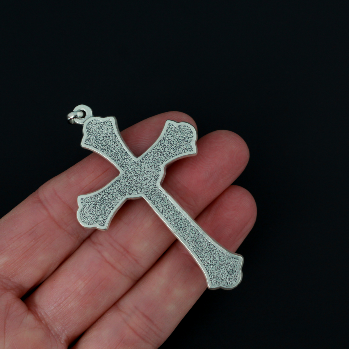 Large ornate crucifix with flared edges. Beautiful raised relief scroll work pattern on the bars of the cross.