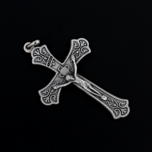 Large ornate crucifix with flared edges. Beautiful raised relief scroll work pattern on the bars of the cross.