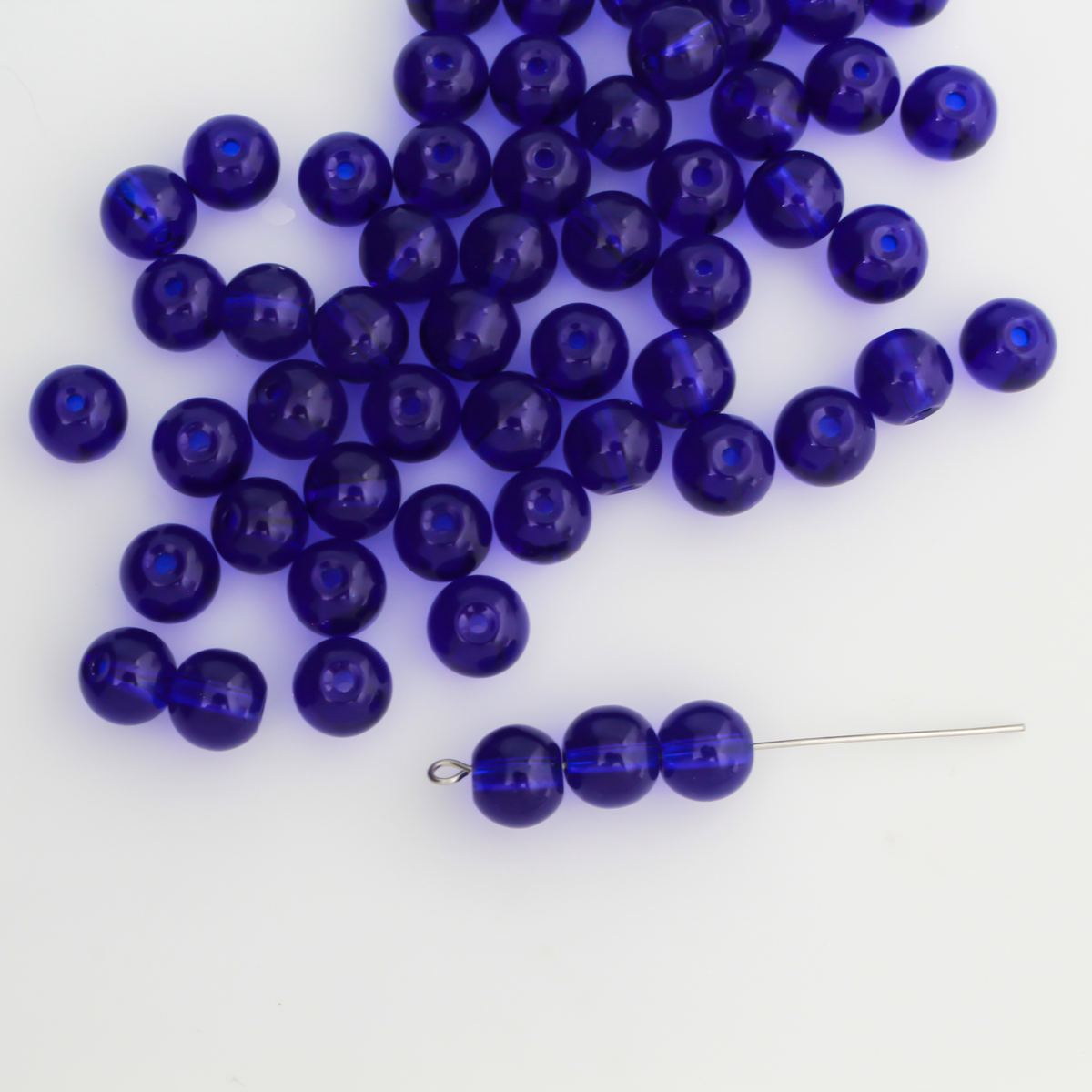 8mm round glass beads in a dark midnight blue color that is transparent.