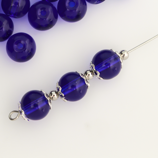 8mm round glass beads in a dark midnight blue color that is transparent.